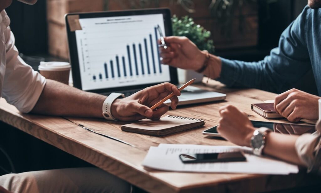 cropped image of business partners discussing documents and ideas at meeting in office