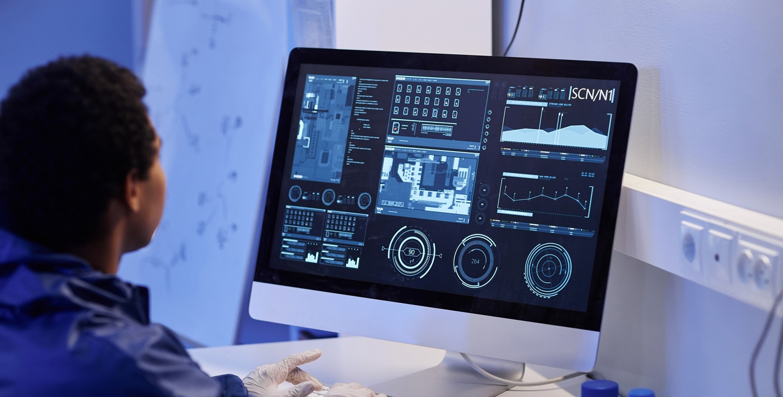 Worker using computer with scientific data in laboratory