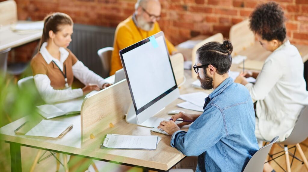 cozy workspace adorned with rustic brick walls, a diverse group of professionals immerses themselves in their tasks