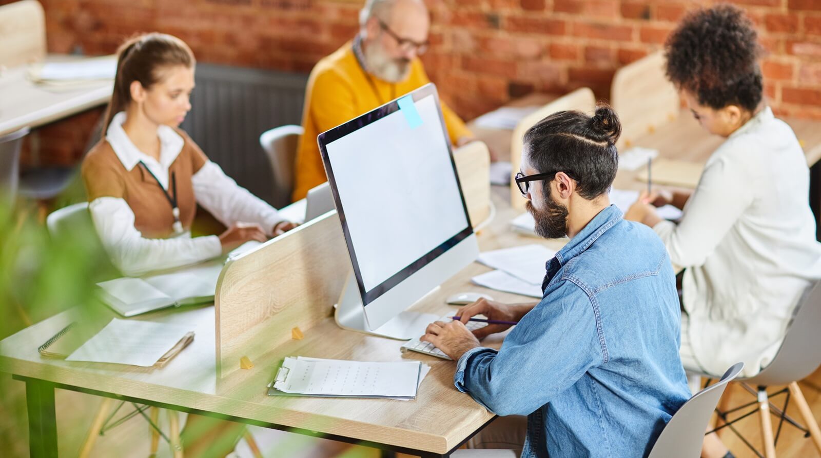 cozy workspace adorned with rustic brick walls, a diverse group of professionals immerses themselves in their tasks
