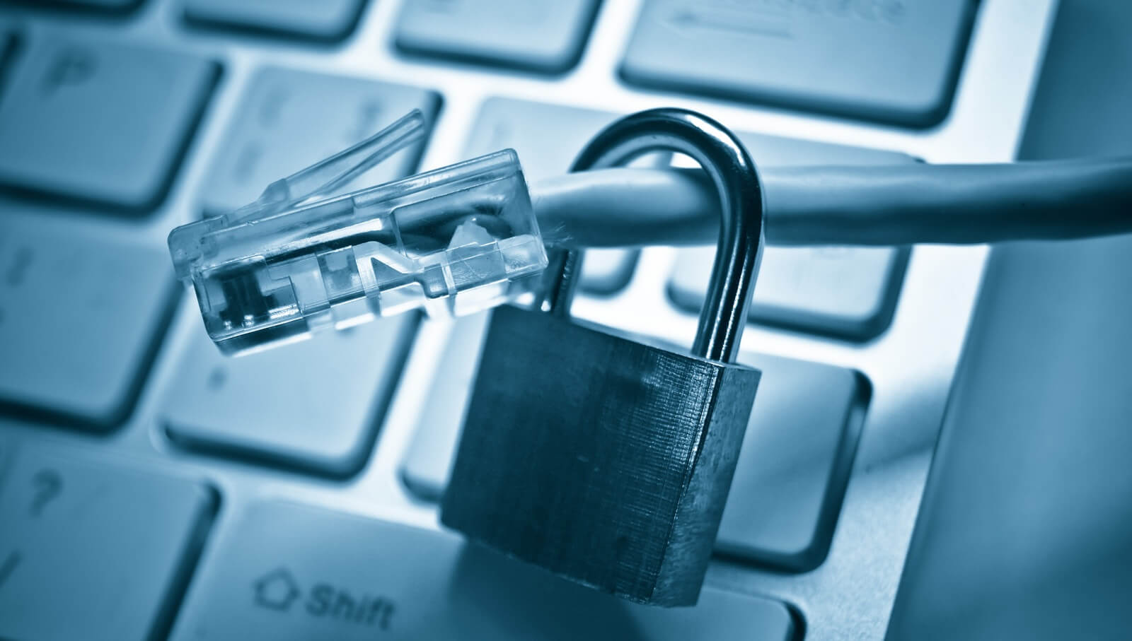 hand holding a security lock with lan wire on computer keyboard