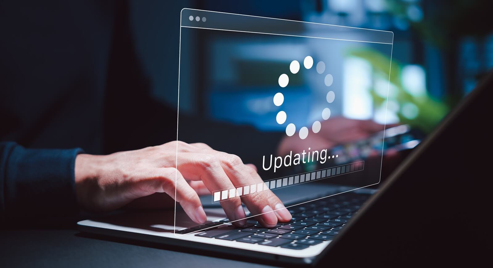 person holding phone while using laptop with software update progress interface and security, technology maintenance