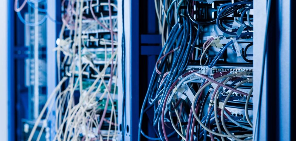 Server rack with fiber optic cables attached to front panel switch ports