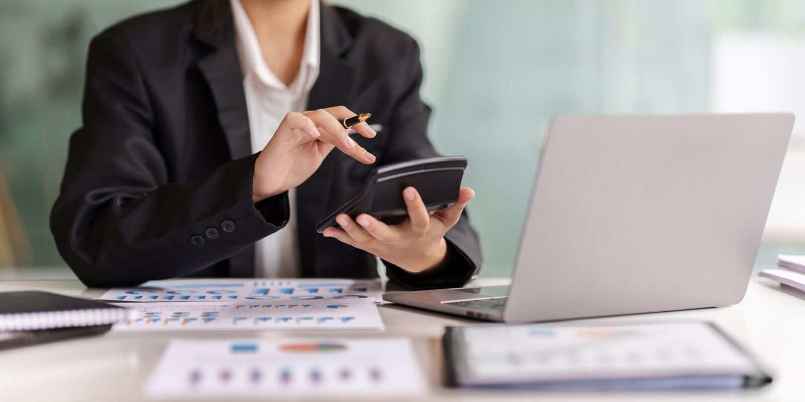 woman hand using calculator to calculate the companys financial results and budget