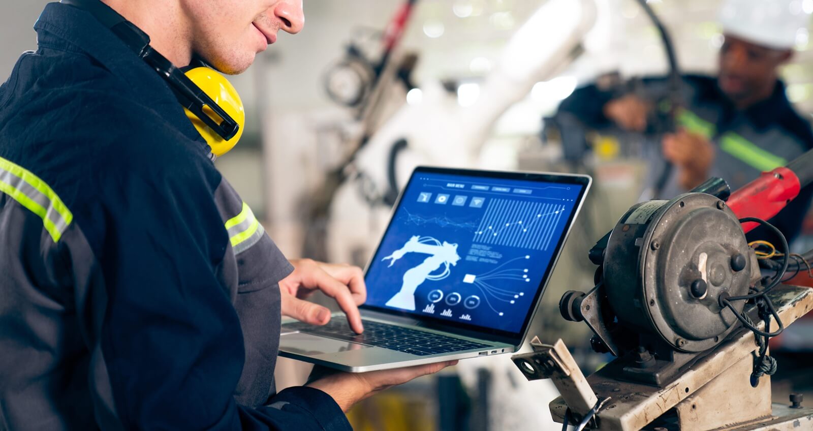 young factory worker working with adept robotic arm in a workshop