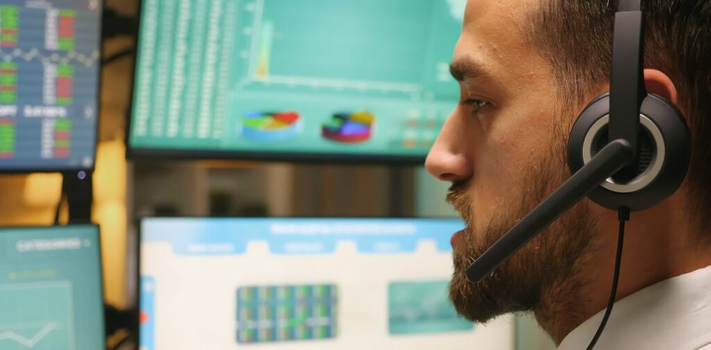 zoom in shot of stock market trader talking with investors wearing headphones