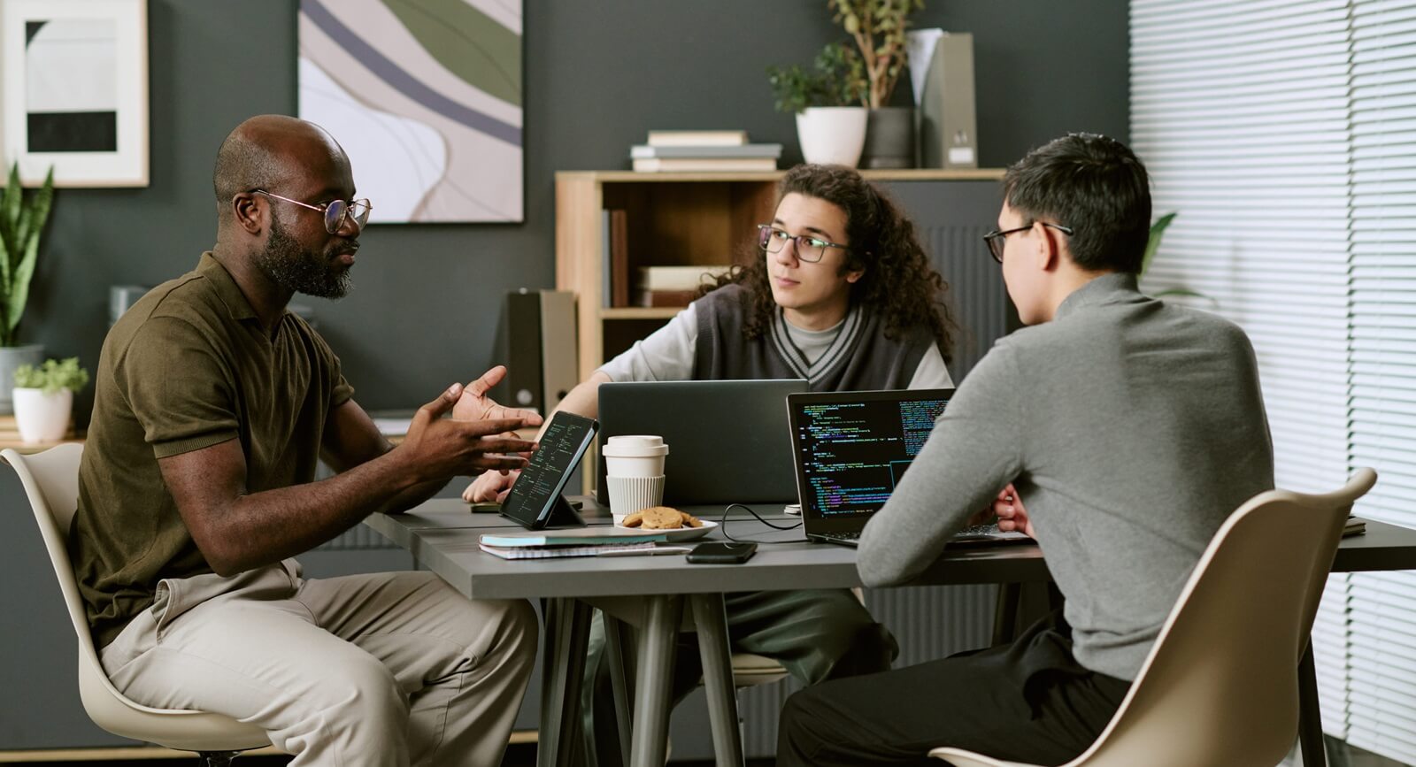 Multiethnic group of young adult men collaborating around table