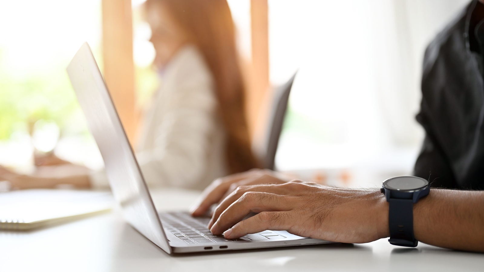 businessman or male office worker using laptop computer, typing on keyboard at his office desk