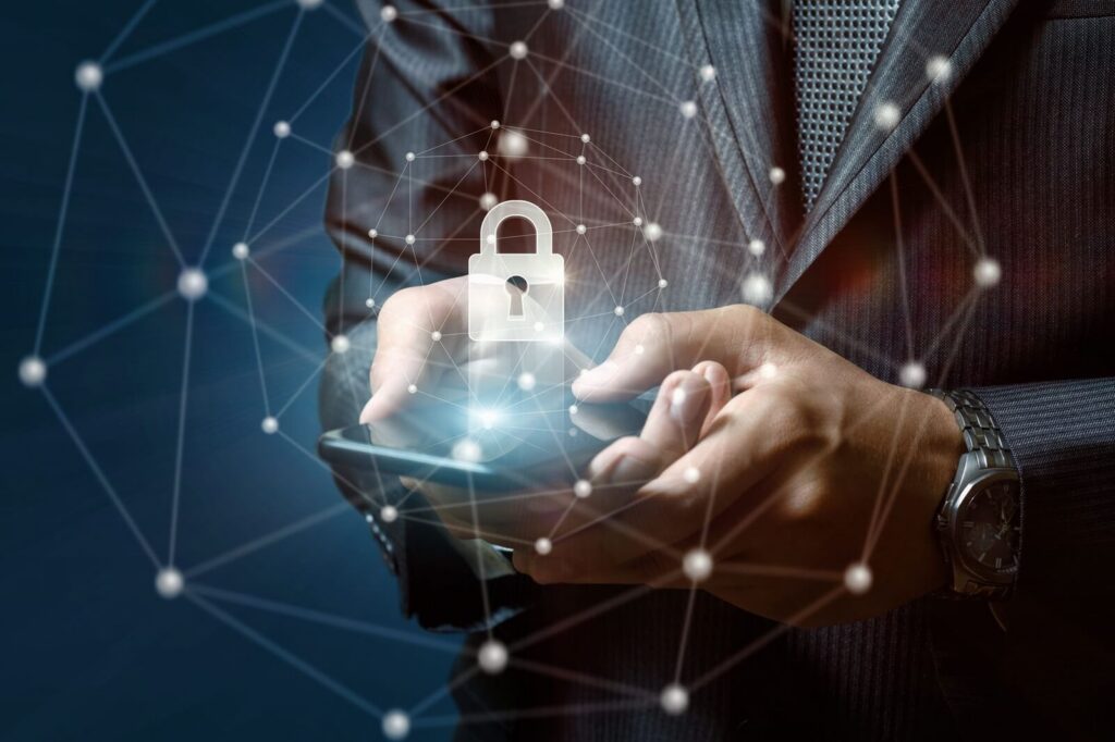 businessman puts a security lock in the phone on a blue background