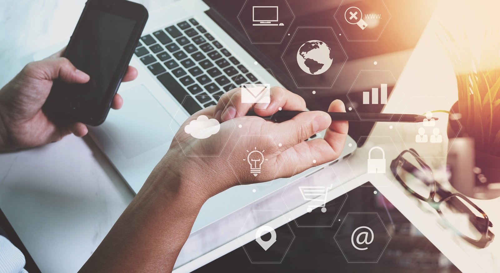 businessman working with smart phone and laptop computer on wooden desk in modern office with virtual icons interface