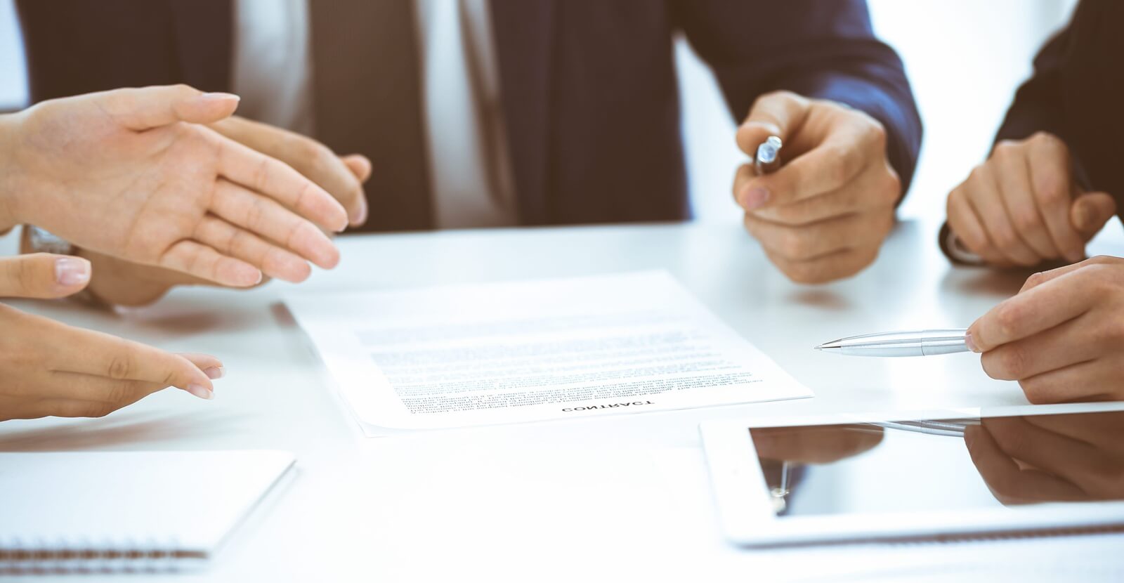 business people and lawyers discussing contract while sitting at the table in office