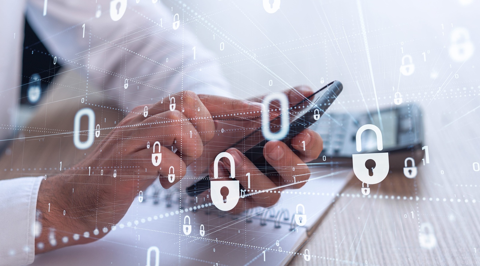A programmer is browsing the Internet in smart phone to protect a cyber security from hacker attacks and save clients confidential data. Padlock Hologram icons over the typing hands. Formal wear.