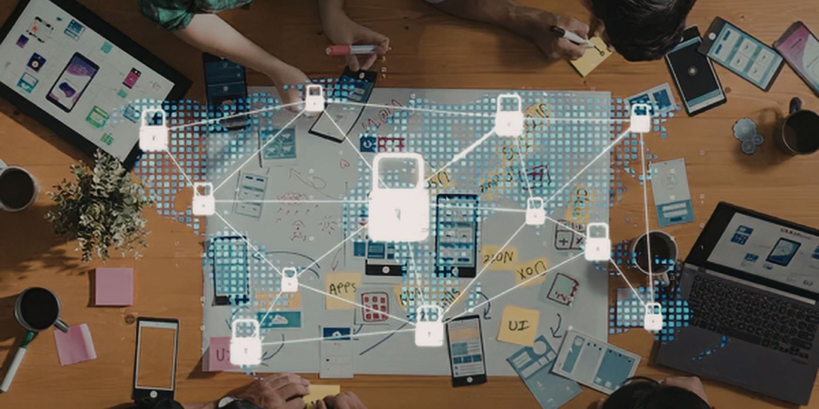 Overhead view of people working on a project with a map and laptops