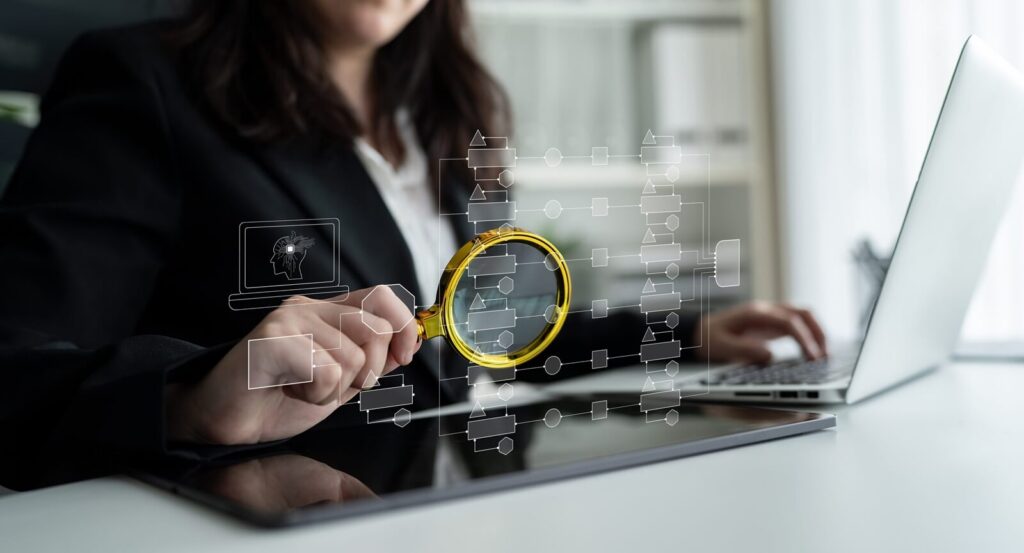 businesswoman analyzing digital data with magnifying glass and laptop in modern office