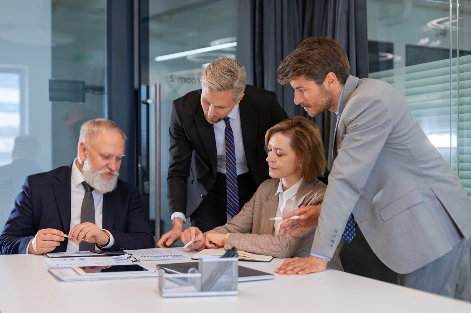 successful businesspeople working in a coworking space working with laptop discussing strategy and business plan in modern office