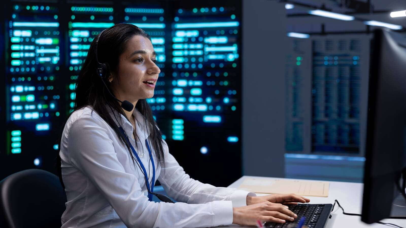 smiling engineer in data center providing support for companies, troubleshooting malfunctions