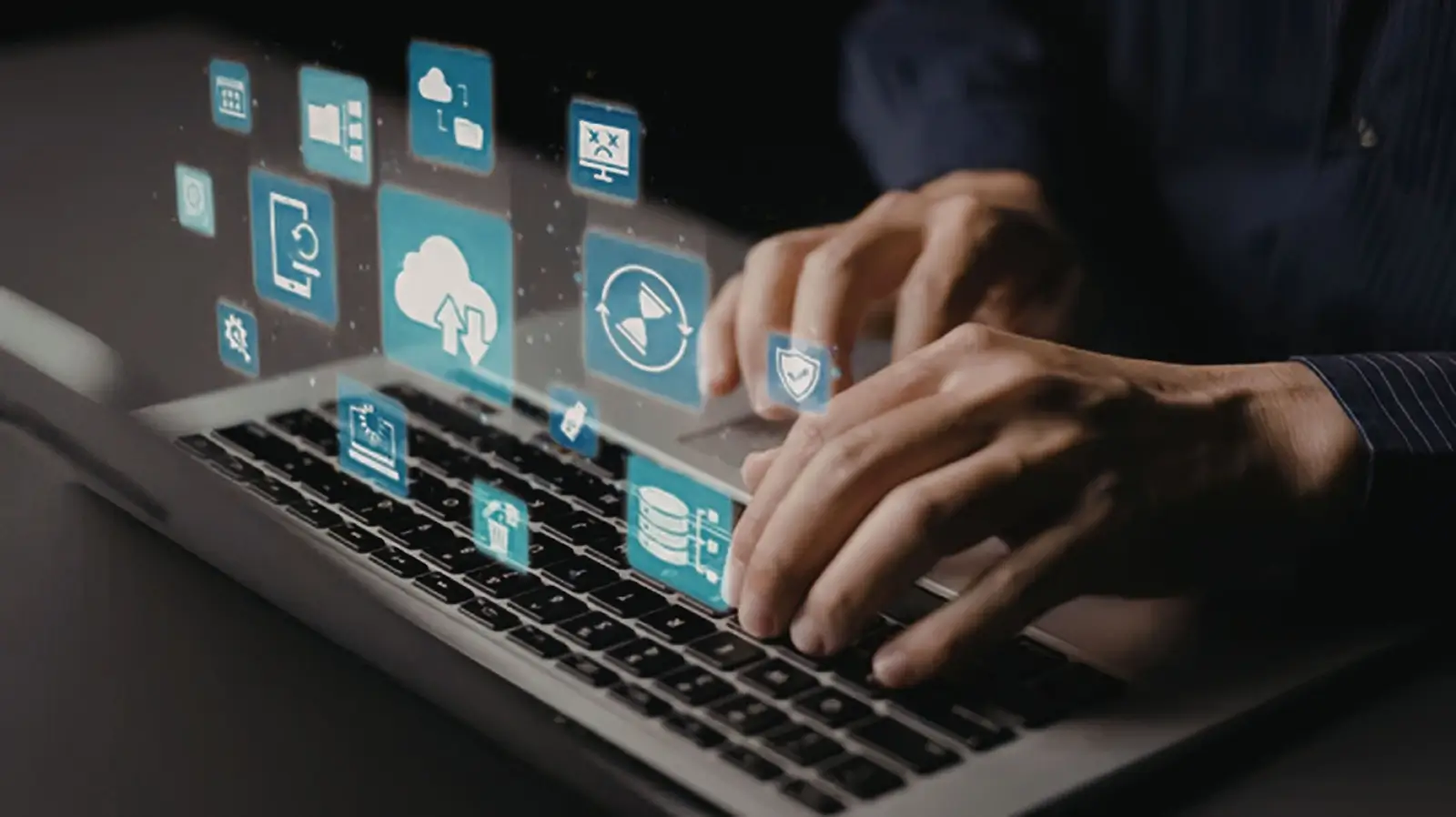 person typing on a laptop with digital icons floating above the keyboard