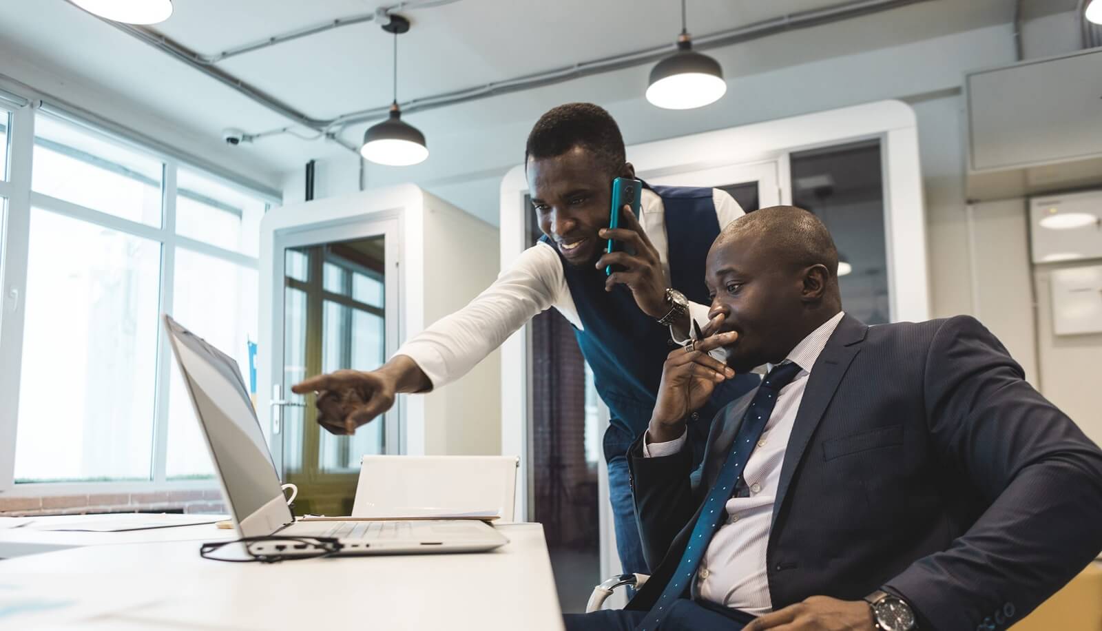 two African American business partners are working on a laptop together on a joint project